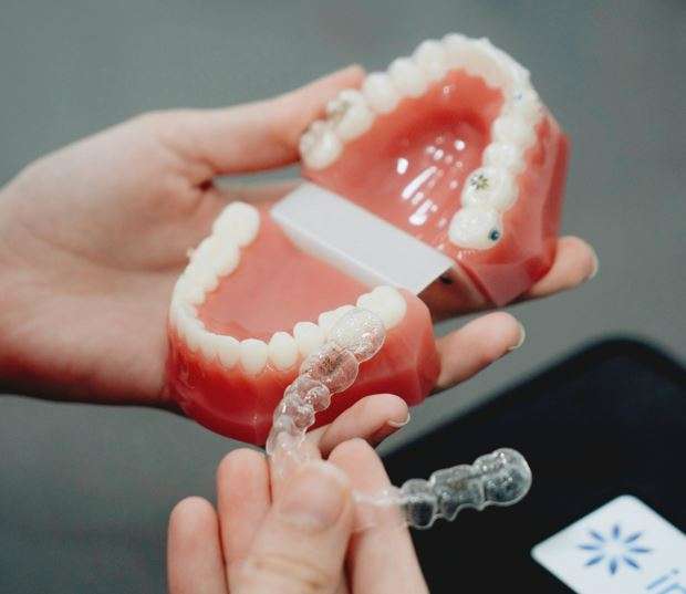 Dentist showcasing Invisalign clear aligners for straighter teeth. If you are looking for Invisalign clear aligners then you can visit Jain dental Hospital Indirapuram, Ghaziabad & Noida, india.