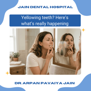 Indian adult looking at slightly yellow teeth in mirror, explaining why teeth turn yellow over time